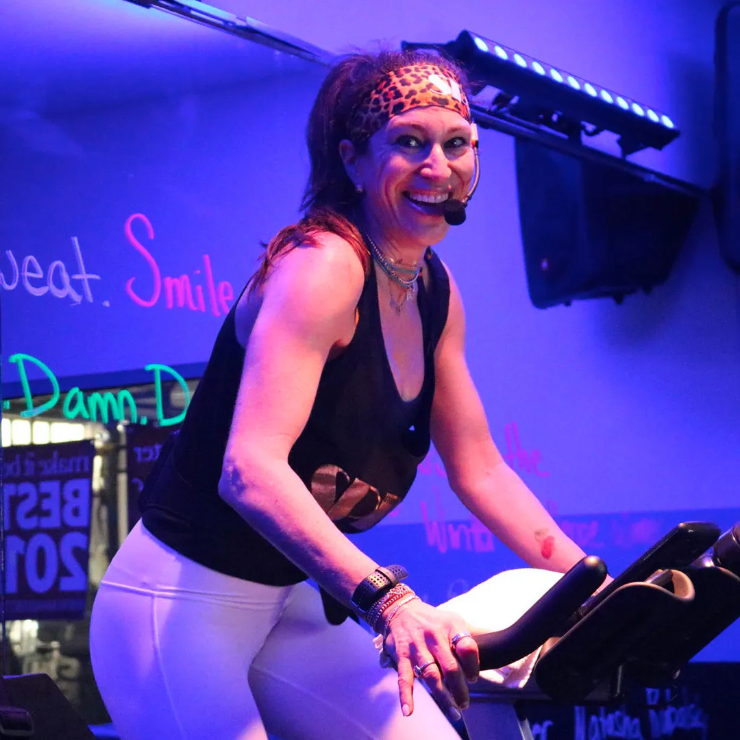 Studio Spin coach guiding a class from the bike